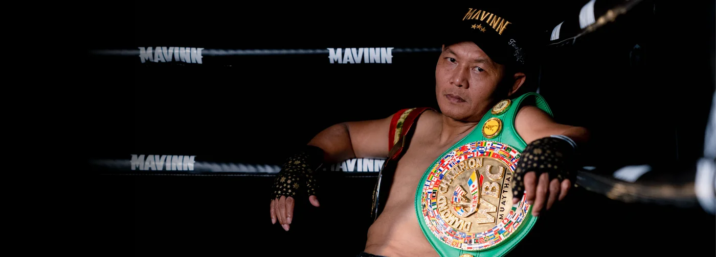 Home A MAVINN Muay Thai fighter with a championship belt in the gym ring
