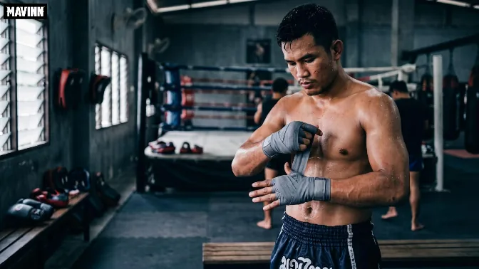 Fighter wrapping his hands inside a Muay Thai gym in Bangkok before training