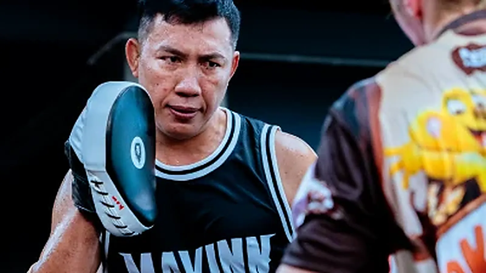 MAVINN trainer holding focus mitts for a student