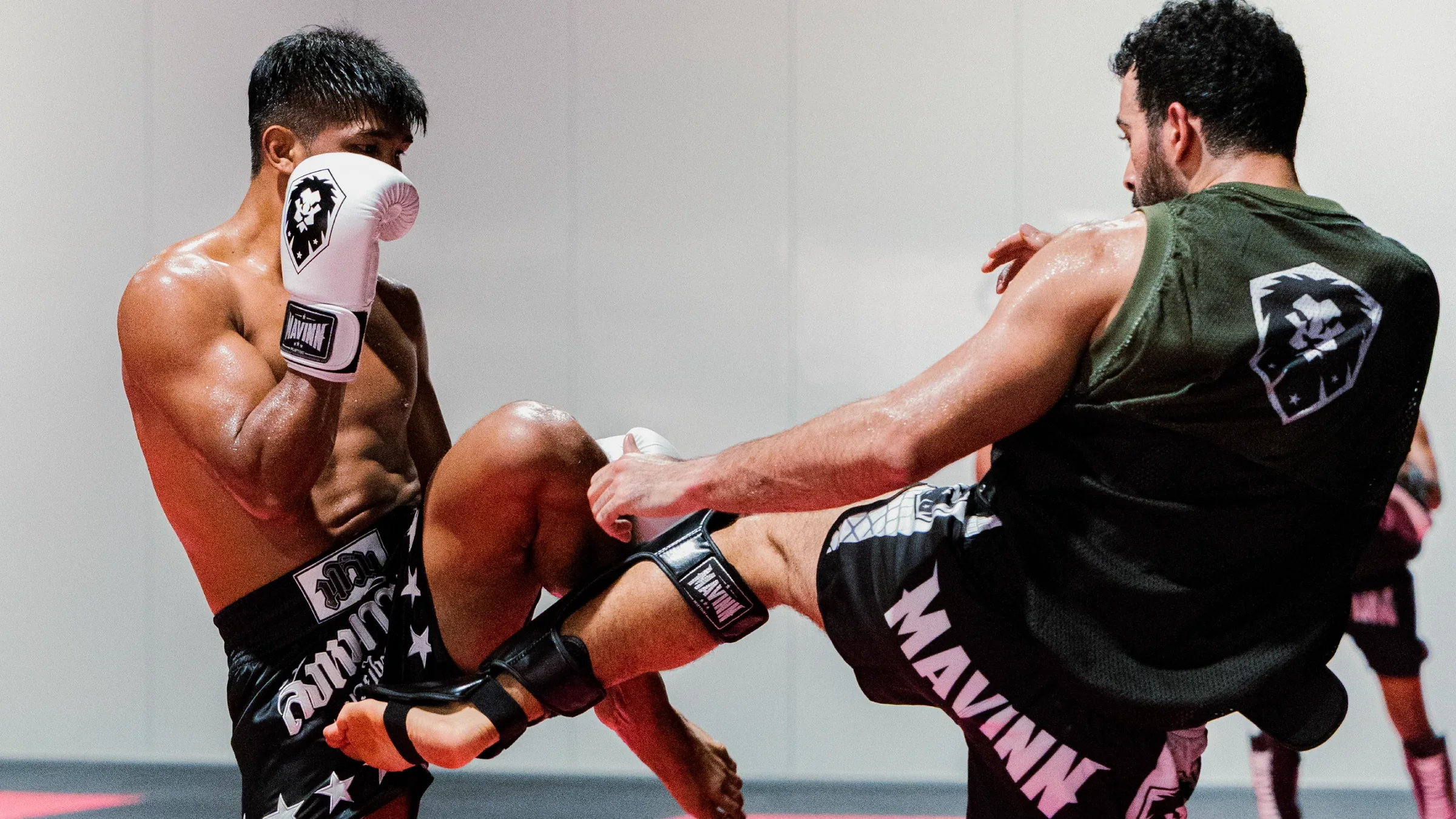 Two MAVINN fighters exchanging kicks during a sparring round