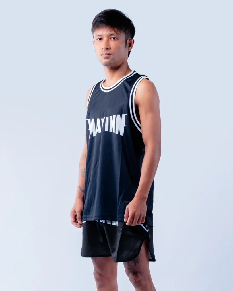 Singnum in MAVINN team vest and Muay Thai shorts, forearm tattoo visible